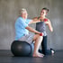Elderly man lifts weights on stability ball to restore mobility.