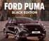 Ford Puma Black Edition. Neue Ausstattungslinie in schwarz. Fahrzeug steht auf der Straße in der Stadt für einem hohen Gebäude.
