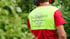Gärtner in Warnweste mit Logo „Da Holzknecht Baumpflege Gartenbau“ arbeitet im Grünen.