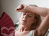 Woman seeking relief from menopause symptoms while fanning herself.