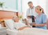 Pflegekraft und Arzt besprechen die Behandlung am Krankenbett