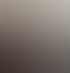 Frau mit Brille und roter Strickjacke sitzt lächelnd am Laptop, eine Pflanze im Hintergrund.