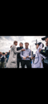 Zwei Männer und eine Frau posieren mit Fans, die eine Mercedes-Benz Flagge halten.