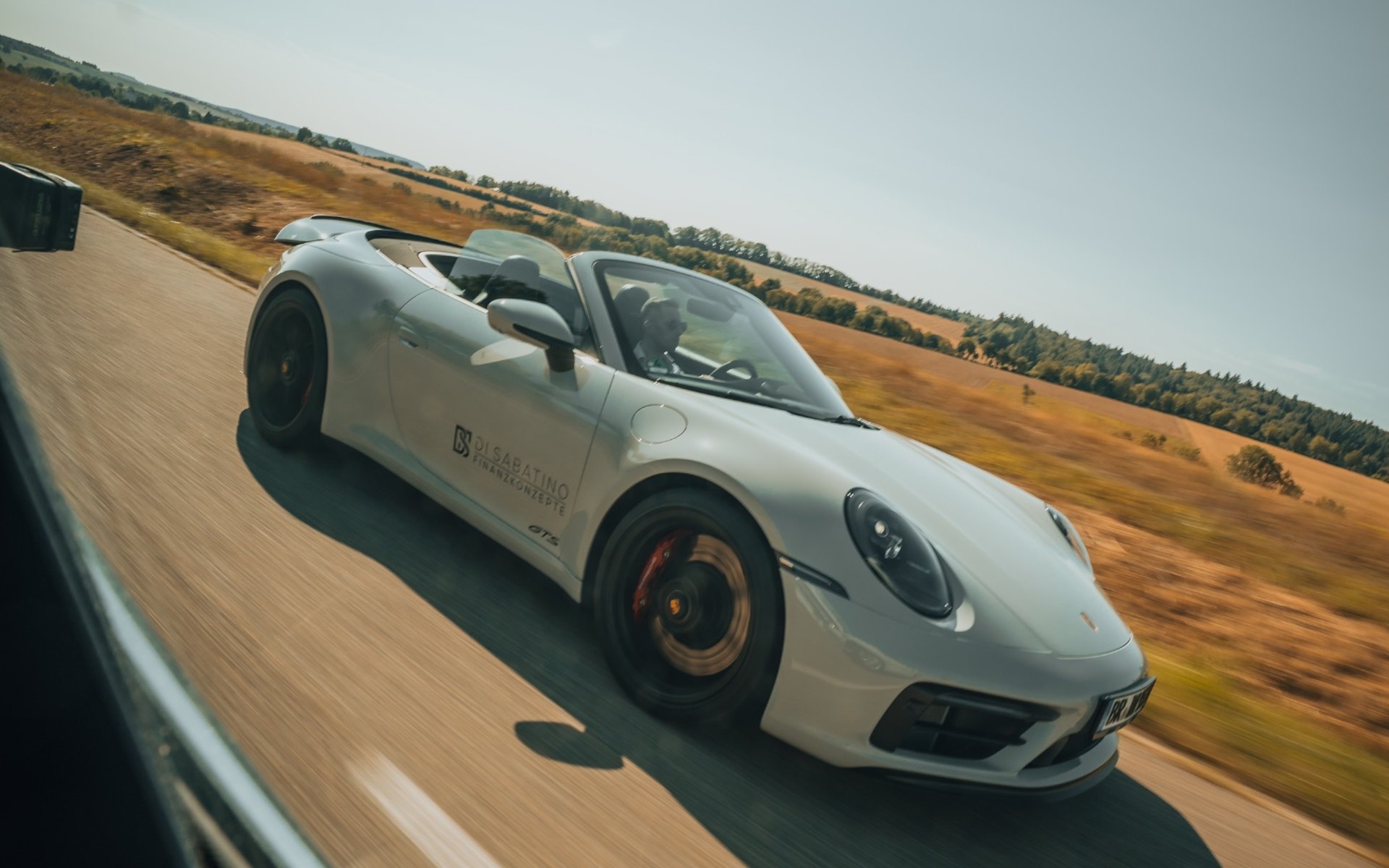 Rolling Shot: Porsche 911 GTS Cabriolet in Bewegung, aufgenommen aus dem Verfolgungsfahrzeug