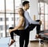 Man and woman in gym gear, balancing on one leg, exercising for joints.
