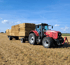 Massey Ferguson 8450 Traktor transportiert Heuballen von einem Feld ab