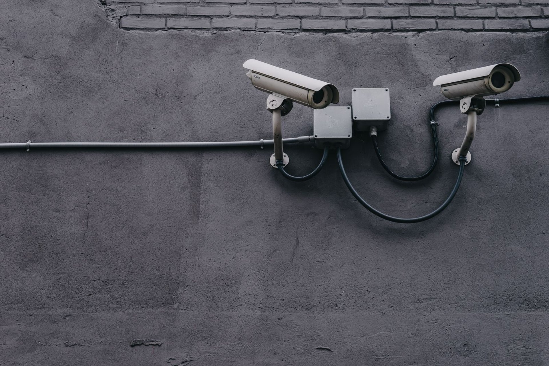 Two exterior bullet security cameras mounted on a wall