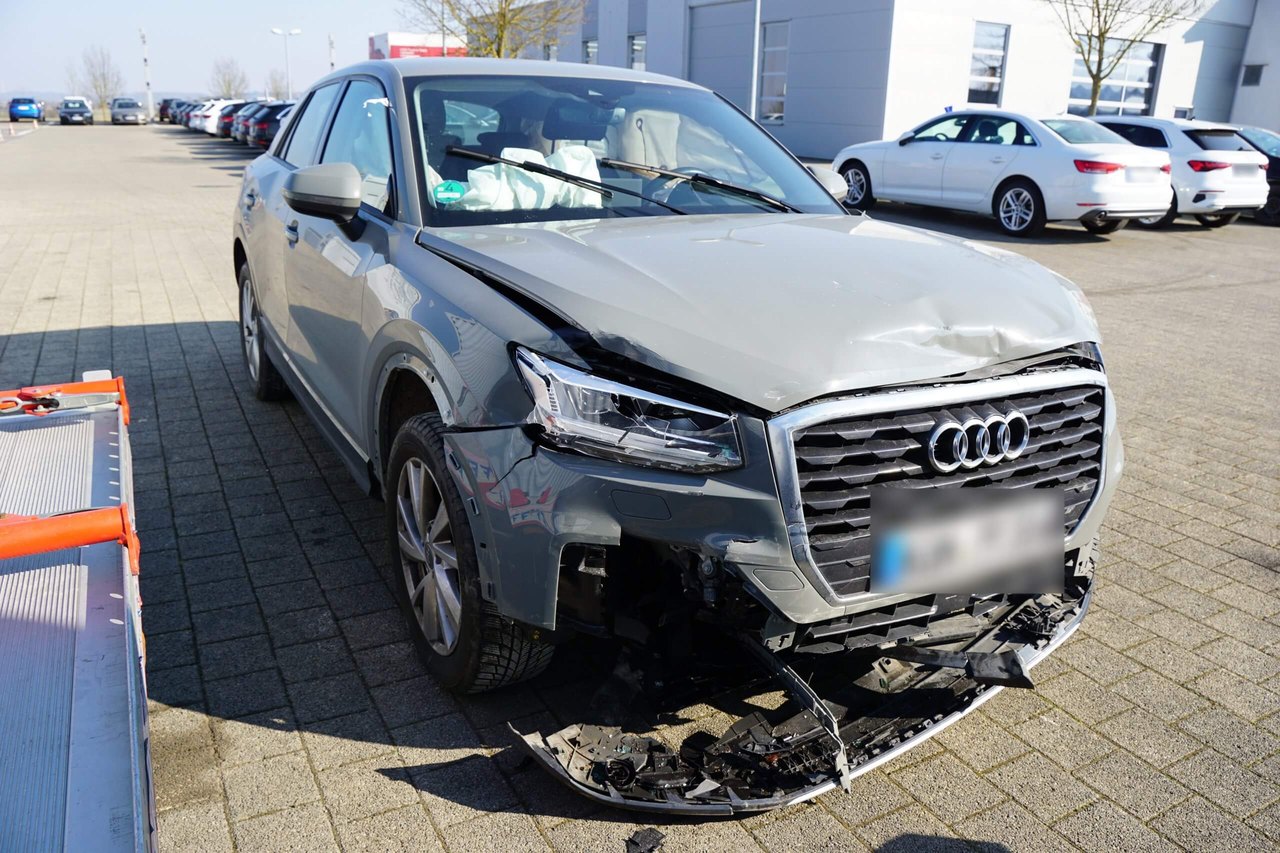 Silbergrauer Audi mit stark beschädigter Front nach einem Unfall