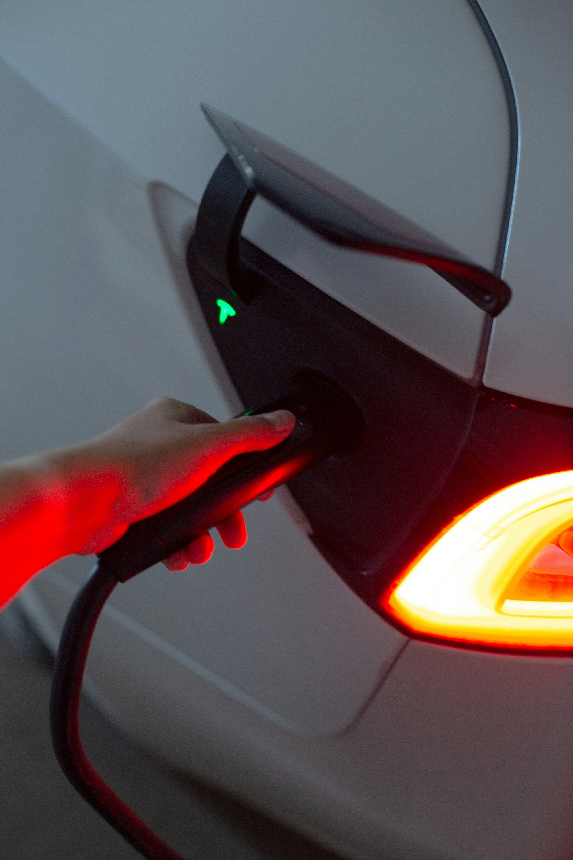 Electric vehicle charging on a home charger showing a green status light