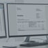 Digitale Rechnung mit dem Titel Invoice auf einem Computermonitor neben einer Tabelle mit Buchhaltungsdaten.