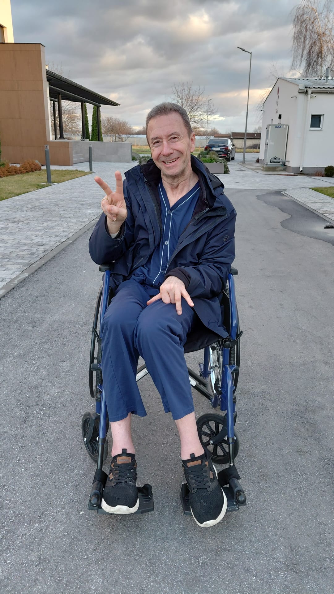 Thorsten, Klient von Pflegeteam to huus, lächelnd mit Victory-Zeichen