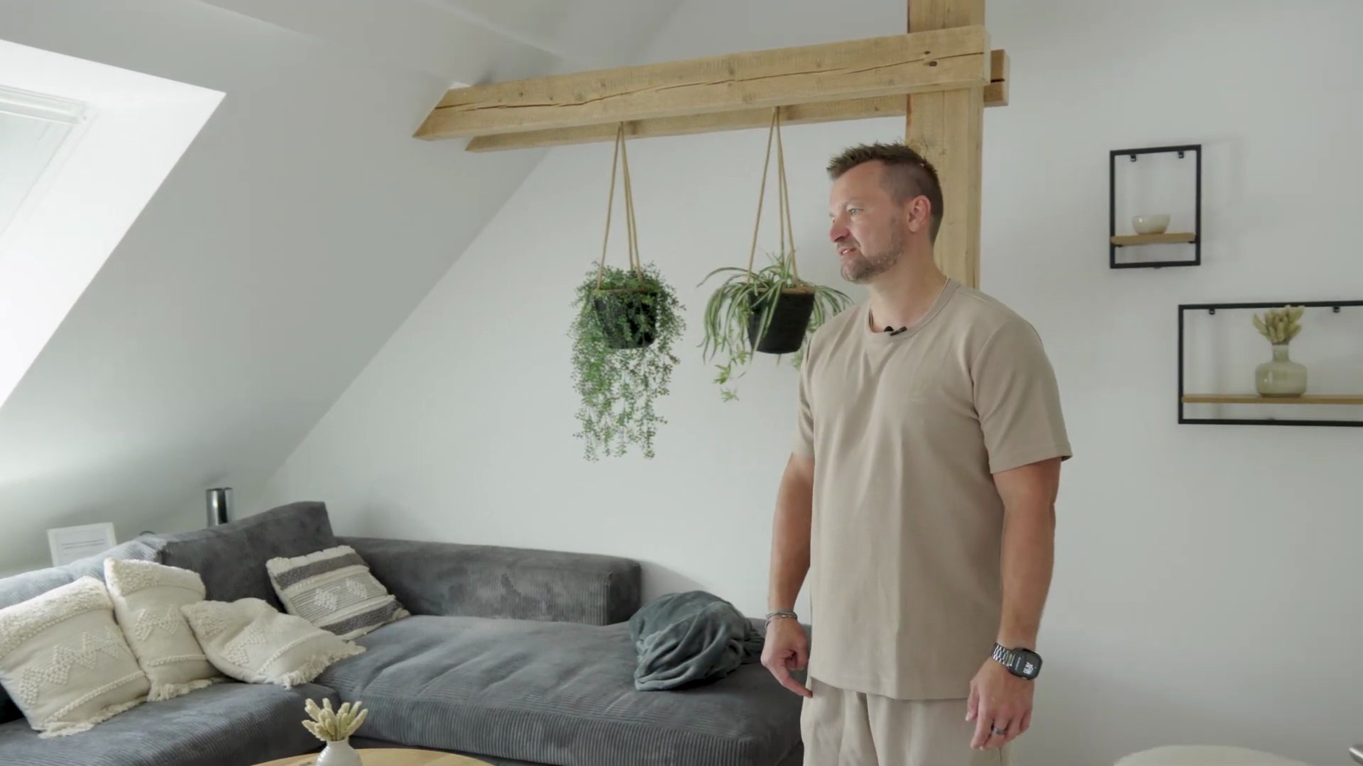 Fertig eingerichteter Wohnbereich mit Holzbalken und Sofa in Björns Ferienwohnung auf einem umgebauten Bauernhof