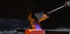 Metallkügelchen werden aus einer Schaufel in einen Schmelztiegel mit blauer und oranger Flamme gegossen.