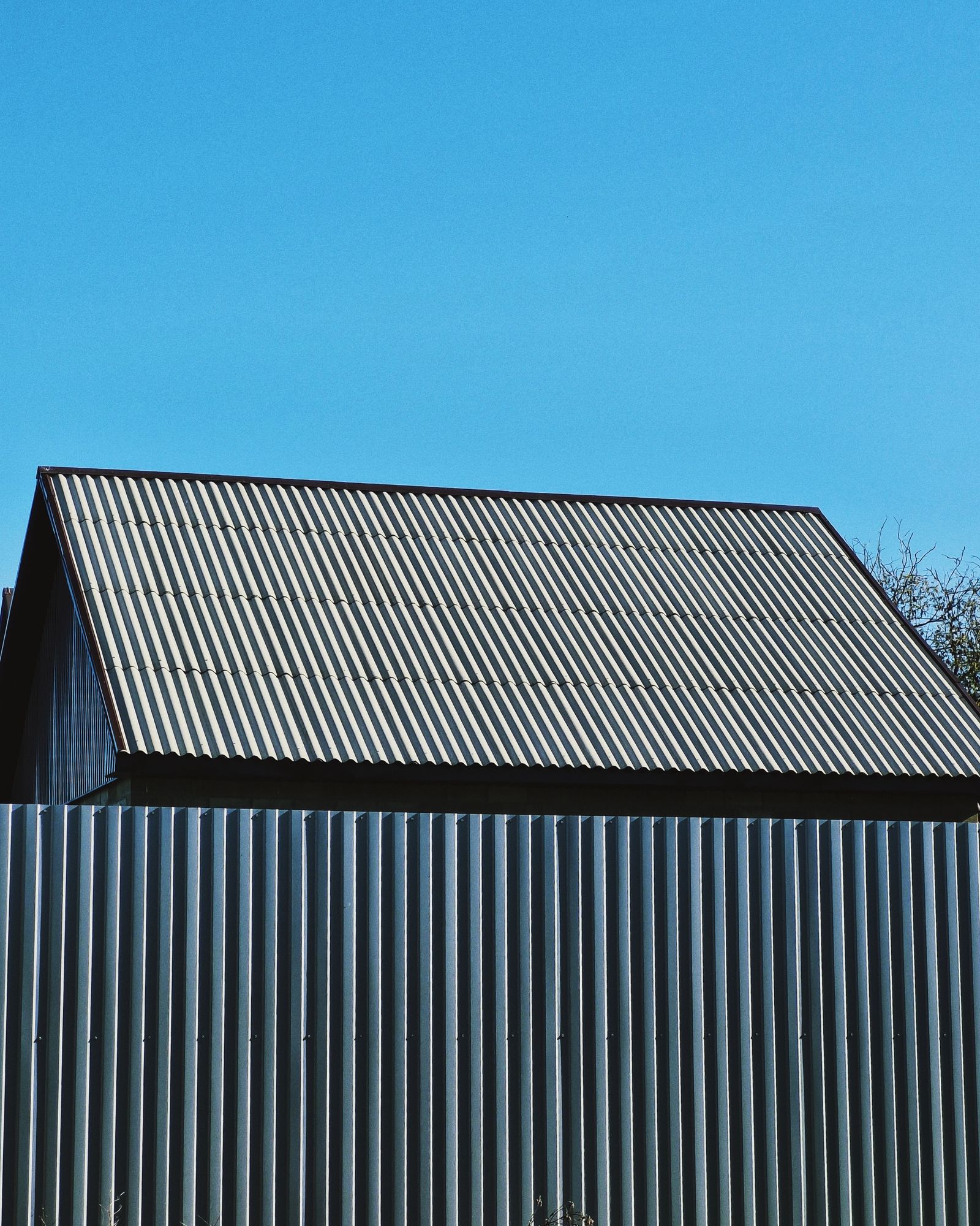 Metal roof panels running in parallel seams against a clear sky