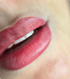 Nahaufnahme von pink-roten Lippen, die leicht geöffnet sind und weiße Zähne zeigen.