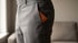 Brown leather wallet in the back pocket of gray dress pants.