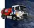 Ein weißer Schrass Entsorgungs-LKW mit rotem Absetzcontainer vor blauem Hintergrund.