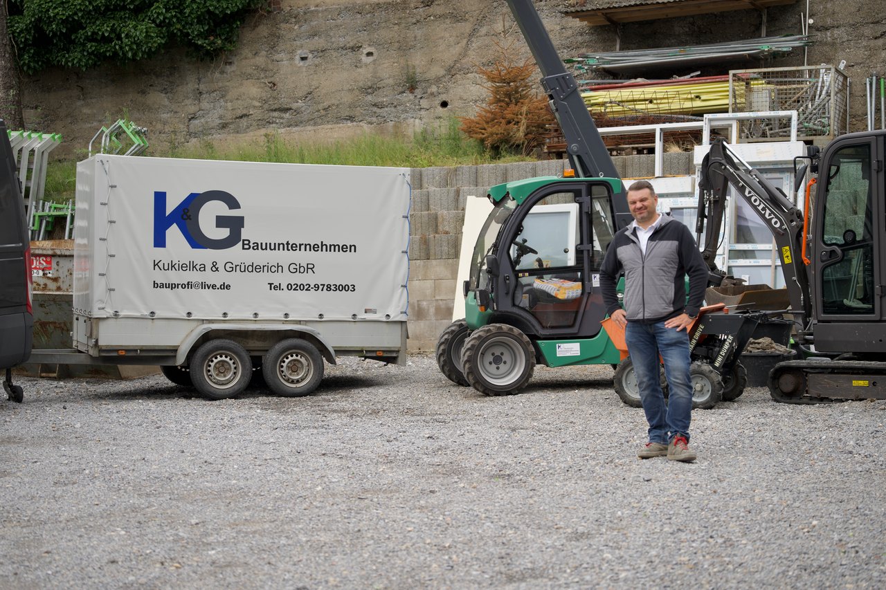 Mitarbeiter von K&G Bauunternehmen mit Stapler am Anhänger