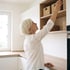 Frau greift ins Küchenregal – der Moment, in dem Beschwerden auffallen