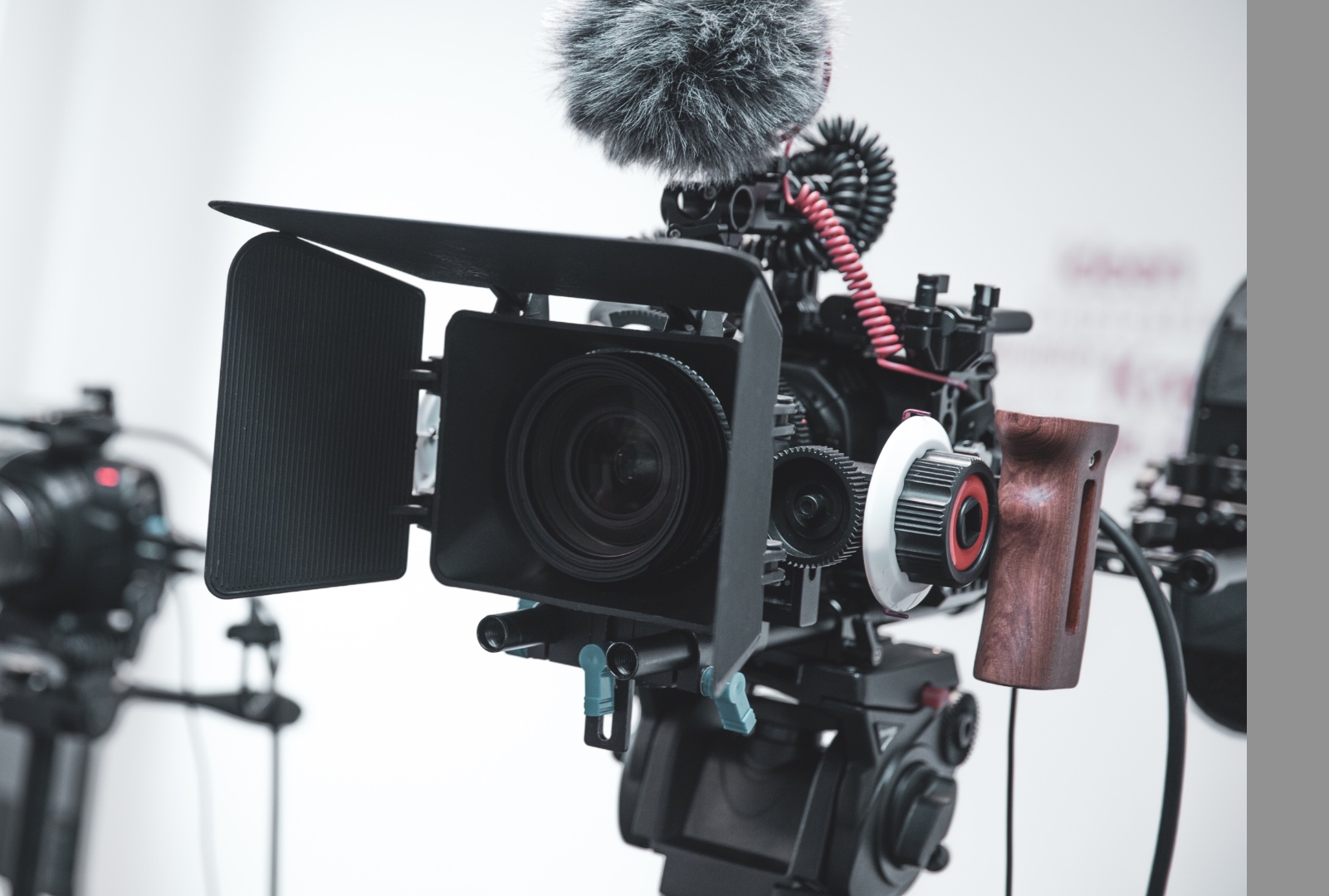 Professionelle Videokamera mit Matte Box, Mikrofon und Holzgriff.