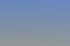 Modernes, graues Industriegebäude mit quadratischen Fensteröffnungen unter blauem Himmel.