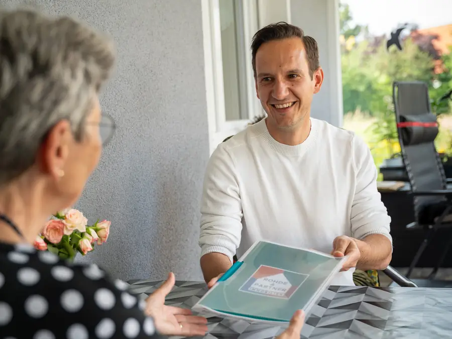 Verkaufsunterlagen für ein Mehrfamilienhaus auf dem Tisch
