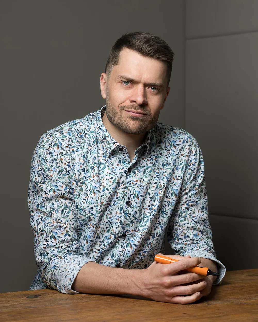 Nils Westrich am Holztisch mit einem Marker in der Hand