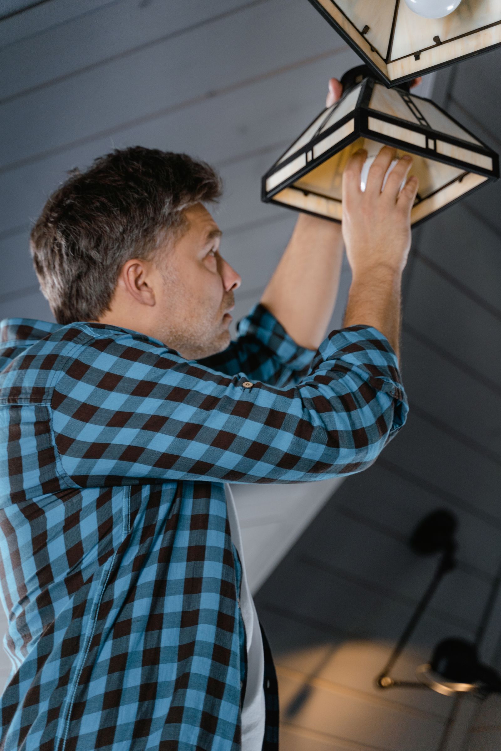 A security technician running low-voltage wiring inside a home