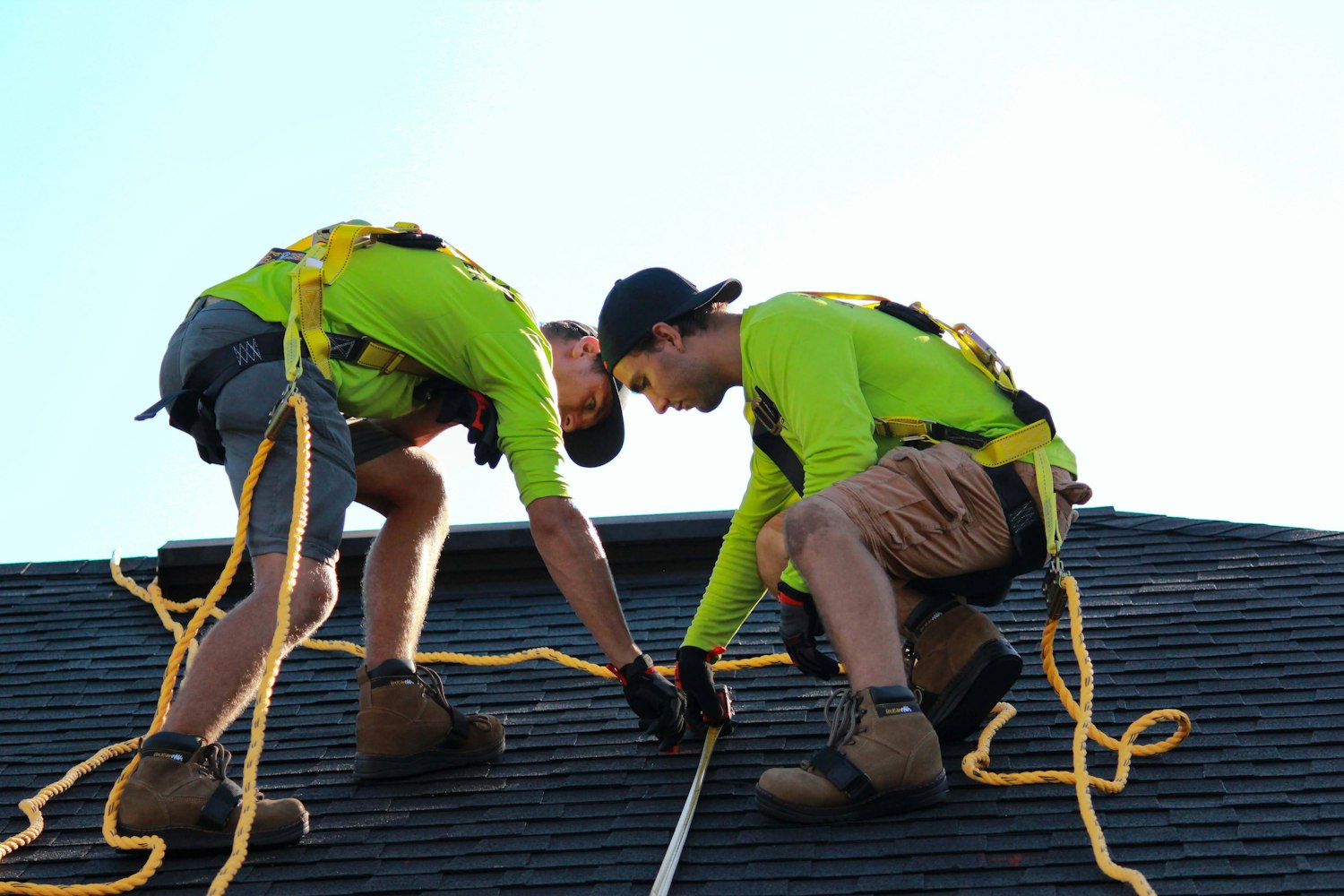Two roofers working together on a residential roof