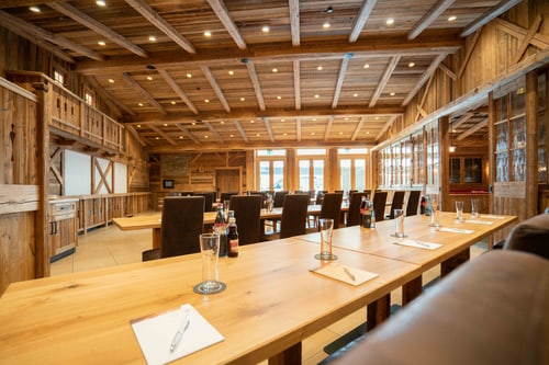 Konferenzraum aus Holz mit langem Tisch und Whiteboard