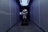 A large silver fist sculpture stands in a dark hallway with blue light strips.