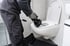 Techniker löst eine WC-Verstopfung mit einer Hand-Rohrreinigungsspirale