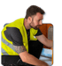 Handwerker in Warnweste bei der Arbeit an einer Anlage