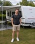 Kevin Schäfer, Gründer von Glamping-Deutschland.de, neben seinem Wohnwagen auf einem Campingplatz