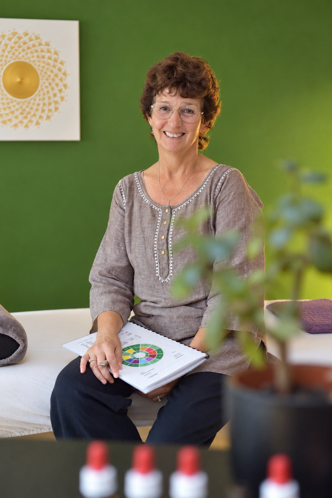 Claudia Schleiss lächelnd auf der Behandlungsliege in ihrer Praxis in Stans