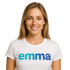 Lächelnde Frau mit langen blonden Haaren, die ein weißes T-Shirt mit der Aufschrift "emma" trägt. Sie ist unsere digitale Assistenz.