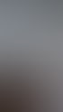 Eine Person wischt eine weiße Wand neben einer Holztreppe mit einem roten Eimer.