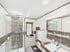 Modernes Badezimmer mit Glasdusche, weißem Waschbecken, Holzunterschrank, Spiegelschrank und gestreiften Wandfliesen.