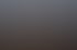 Stromleitungen und Masten bei Sonnenuntergang über einem weiten Feld mit orangefarbenem Himmel.