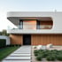 Moderne Modulhauslösung powered by Lindt Haus mit Holzfassade, Glasbalkon und minimalistischer Gartengestaltung
