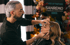Makeup artist applying eyeliner to a woman's eyelid, with a "MAKE UP PARTNER SANREMO 2023" sign in background.