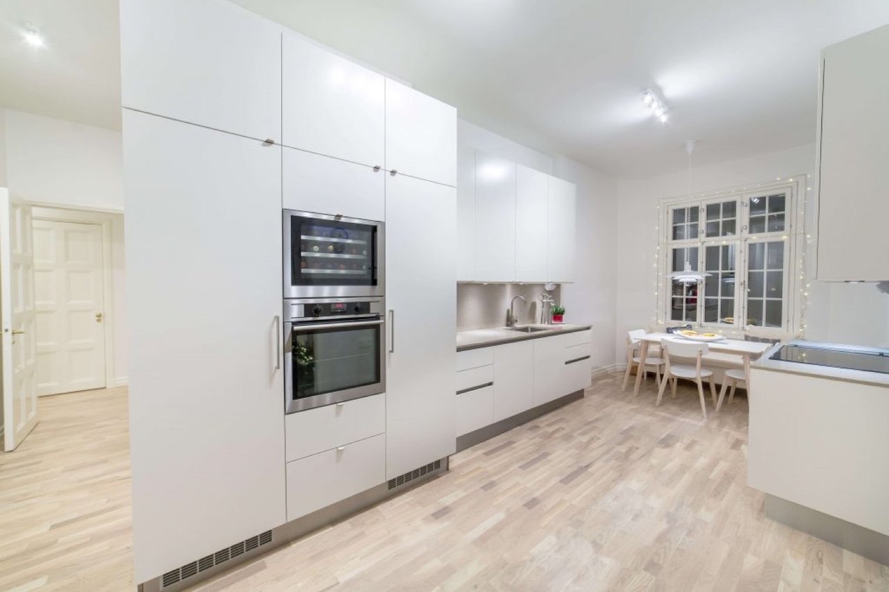 Vitt kök med trägolv efter renovering