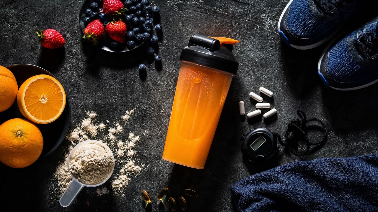 Nutrición deportiva con batido de proteínas, fruta y complementos de entrenamiento.