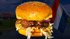 Doppelter Cheeseburger mit Salat und roten Zwiebeln vor einer niederländischen Flagge und nordischen Häusern.