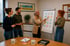 Vier Personen bei einer Besprechung vor einem Flipchart im Büro der Karawane Pflegefamilien.