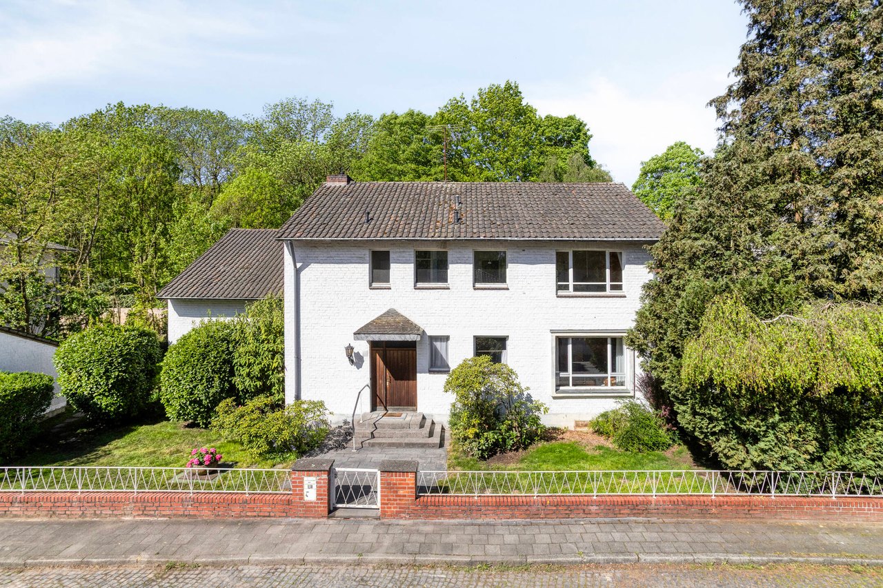 Straßenansicht der freistehenden Villa mit Natursteintreppe am Eingang