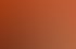 Zwei Frauen sitzen an einem Holztisch vor einer orangefarbenen Wand und unterhalten sich.