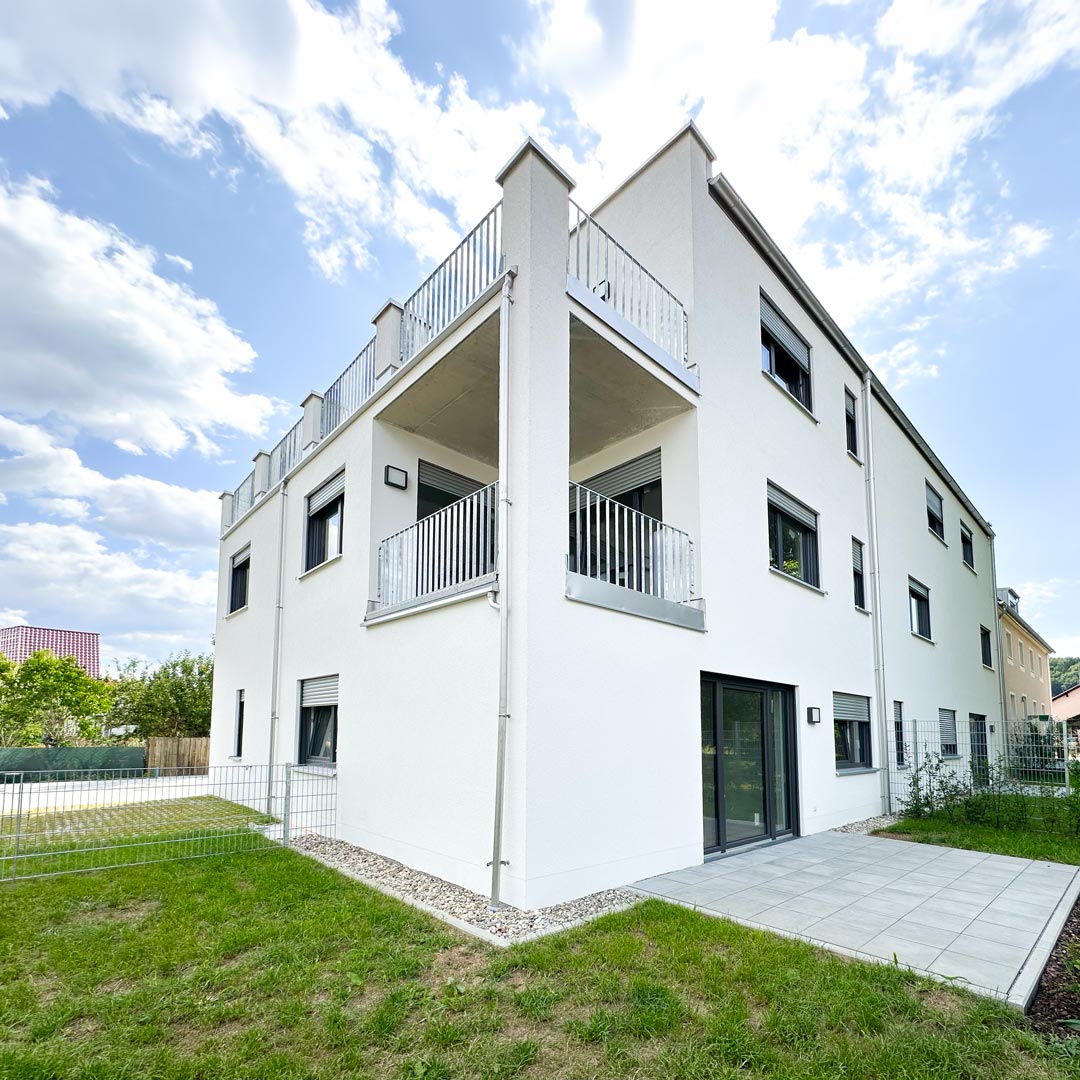 Heller Wohnbereich einer Neubauwohnung mit bodentiefen Fenstern