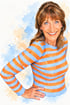 Lächelnde Frau mit braunen Haaren im blau-orange gestreiften Oberteil vor einem abstrakten Aquarell-Hintergrund.
