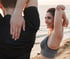 Couple stretching by the ocean, embracing recovery and regenerative care
